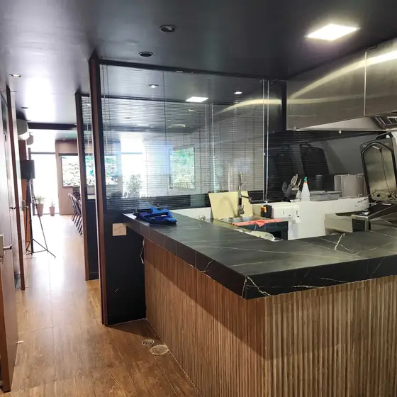 Cozinha-show do Chef's Atelier, anexo ao Espaço Convivium, com bancada de pedra escura